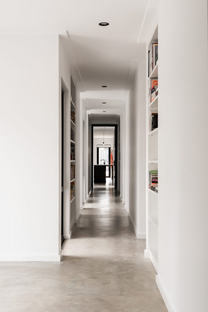 Zimmermann Residence-Mount Claremont-Superseed Architecture-54-Concrete hallway with bookshelves